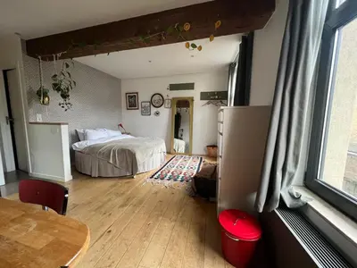 a bedroom with a bed and a table in a room at Cozy studio-city center in Brussels