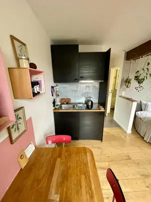 a kitchen with a wooden table in a room at Cozy studio-city center in Brussels