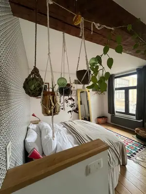 a bedroom with potted plants hanging from the ceiling at Cozy studio-city center in Brussels