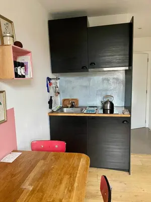 a kitchen with a sink and a wooden table at Cozy studio-city center in Brussels