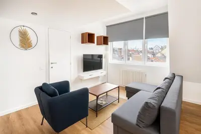 a living room with a couch and a tv at Modern Loft 1BR Sofa Bed 10min to Center in Brussels