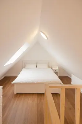 a bedroom with a white bed in a attic at Modern Loft 1BR Sofa Bed 10min to Center in Brussels