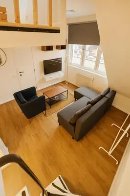 a living room with a couch and a tv at Modern Loft 1BR Sofa Bed 10min to Center in Brussels