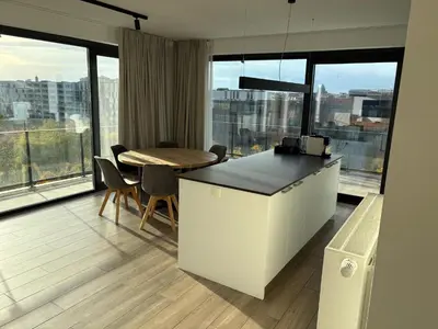 a kitchen and dining room with a table and some windows at Penthouse avec vue imprenable sur Bruxelles in Brussels