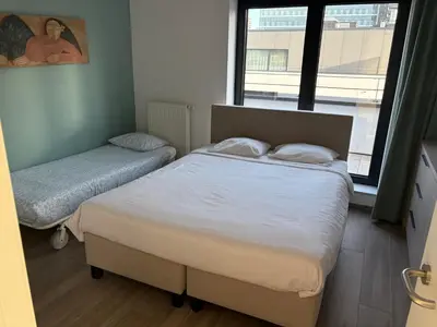 a bedroom with two beds and a window at Penthouse avec vue imprenable sur Bruxelles in Brussels