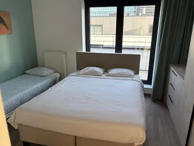 a small bedroom with a bed and a window at Penthouse avec vue imprenable sur Bruxelles in Brussels