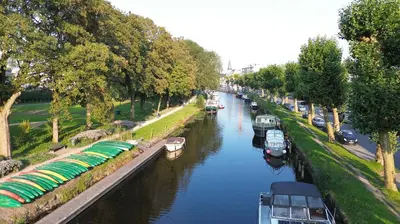 a river with boats parked on the side of it at LoftAnno1940 in Lokeren