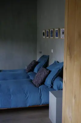 two beds in a room with blue sheets and pillows at 15 inn in Mol