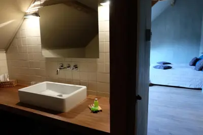 a bathroom with a sink and a bed in a room at 15 inn in Mol
