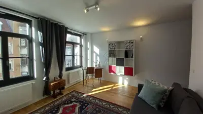 a living room with a couch and some windows at Charming apartment at heart of Brussels-Marolles in Brussels