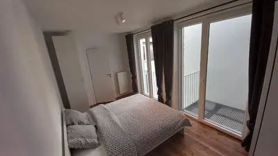 a bedroom with a bed and a large window at Charming apartment at heart of Brussels-Marolles in Brussels