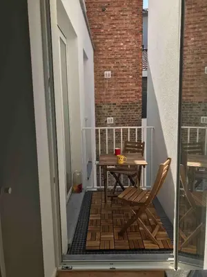 a balcony with a table and chairs on a balcony at Charming apartment at heart of Brussels-Marolles in Brussels
