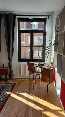 a living room with a desk and a window at Charming apartment at heart of Brussels-Marolles in Brussels
