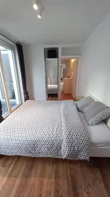 a bedroom with a large white bed with a wooden floor at Charming apartment at heart of Brussels-Marolles in Brussels