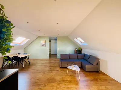 a living room with a blue couch and a table at Ruime studio met eigen ingang en private badkamer in Opwijk