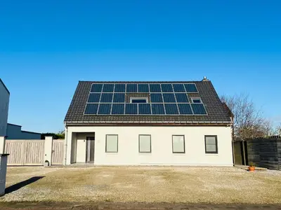 a house with solar panels on the roof at Ruime studio met eigen ingang en private badkamer in Opwijk
