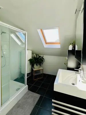 a bathroom with a glass shower and a sink at Ruime studio met eigen ingang en private badkamer in Opwijk