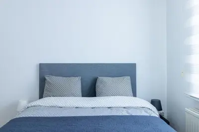 a blue bedroom with a bed with a blue headboard at Apartment-Gravensteen in Ghent