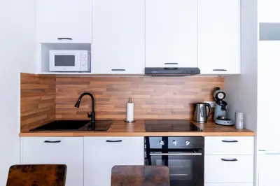 a kitchen with white cabinets and a sink and a microwave at Apartment-Gravensteen in Ghent