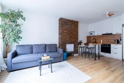 a living room with a blue couch and a kitchen at Apartment-Gravensteen in Ghent