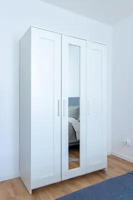 a white wardrobe with doors in a room at Apartment-Gravensteen in Ghent