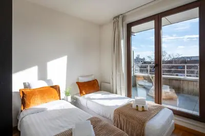 two beds in a room with a balcony at Brussels EU Center residence in Brussels