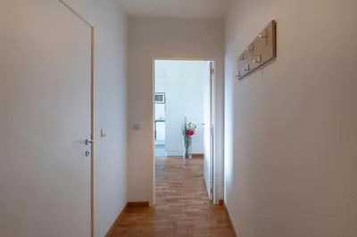 a hallway with a door and a vase of flowers at Brussels EU Center residence in Brussels