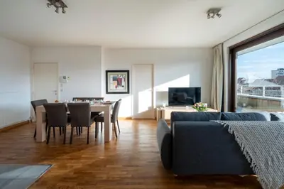 a living room with a blue couch and a table at Brussels EU Center residence in Brussels