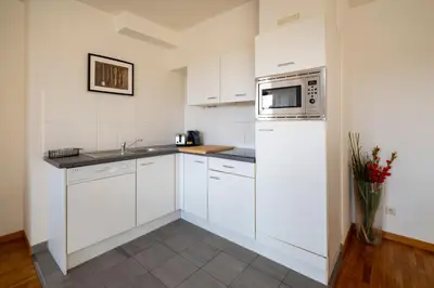 a kitchen with white cabinets and a microwave at Brussels EU Center residence in Brussels