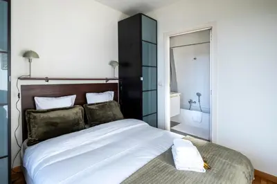 a bedroom with a large bed and a bathroom at Brussels EU Center residence in Brussels
