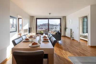 a dining room and living room with a table and chairs at Brussels EU Center residence in Brussels