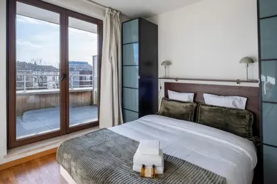 a bedroom with a bed and a large window at Brussels EU Center residence in Brussels