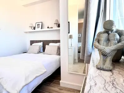 a bedroom with a bed and a statue in a mirror at Lovely appartment - Heart of Brussels for 2 view over the city in Brussels