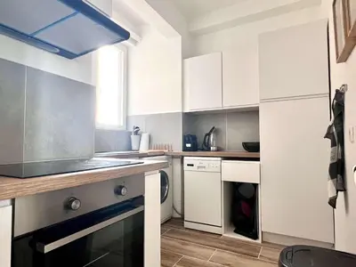 a small kitchen with white cabinets and a dishwasher at Lovely appartment - Heart of Brussels for 2 view over the city in Brussels