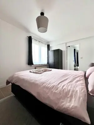 a bedroom with a large bed with a large window at lovely 2room Elegant Apartment in Brussels for 2people in Brussels