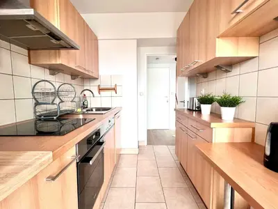 a kitchen with wooden cabinets and a counter top at lovely 2room Elegant Apartment in Brussels for 2people in Brussels