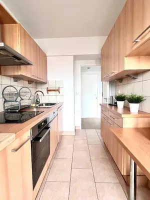 a large kitchen with wooden cabinets and a sink at lovely 2room Elegant Apartment in Brussels for 2people in Brussels