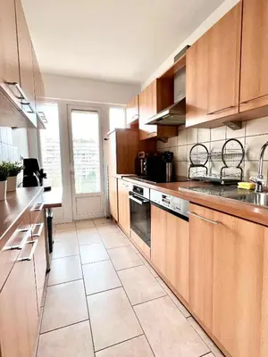 a kitchen with wooden cabinets and a large tile floor at lovely 2room Elegant Apartment in Brussels for 2people in Brussels
