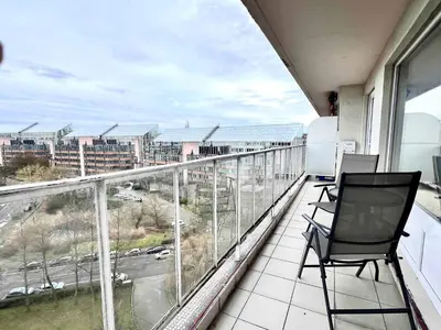 a balcony with two chairs and a view of a city at lovely 2room Elegant Apartment in Brussels for 2people in Brussels