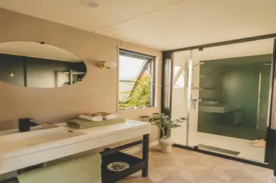 a bathroom with a sink and a shower and a mirror at 6-Guest Escape with Private Garden & Wi-Fi in Ravels