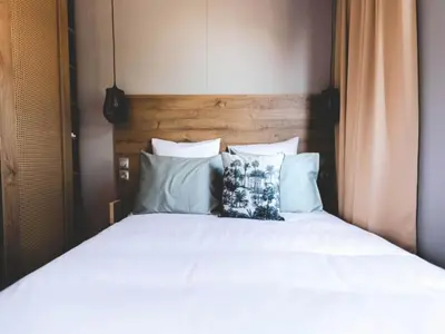 a bed with white sheets and blue pillows at Two-Bedroom Retreat in the Heart of Kempen in Ravels