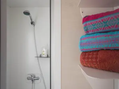 a bathroom with a stack of towels on a shelf at Beach lodge with lake view in Ravels in Ravels