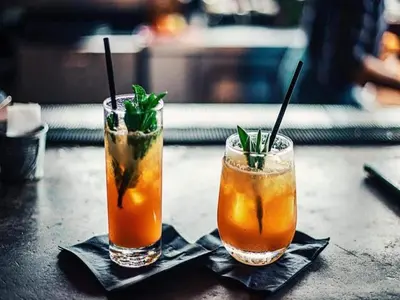 two cocktails sitting on top of a table at Beach lodge with lake view in Ravels in Ravels