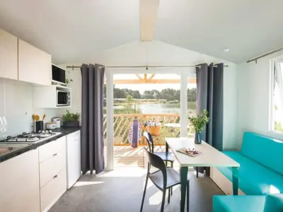 a kitchen and dining room with a table and chairs at Beach lodge with lake view in Ravels in Ravels