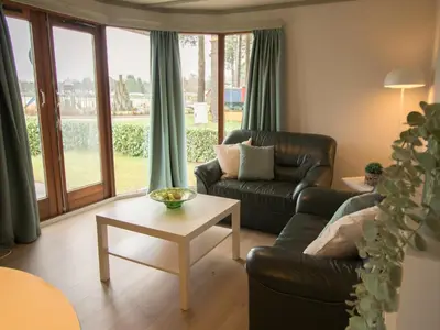 a living room with a couch and a table at Stay with Beach and Minigolf Views in Ravels