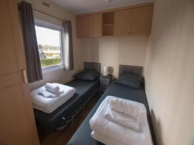 a small room with two beds and a window at 3-Bedroom Central Retreat in Ravels in Ravels