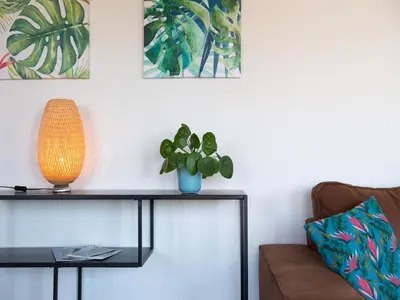 a living room with a couch and a table with a plant at Luxury Forest Lodge with Private Garden in Ravels
