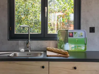 a kitchen counter with a sink and a cutting board at Luxury Forest Lodge with Private Garden in Ravels