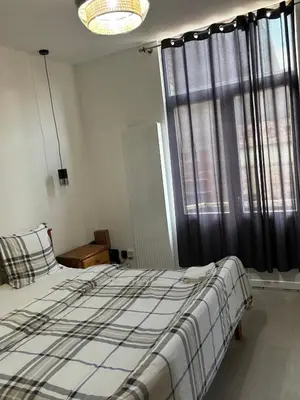 a bedroom with a bed and a large window at Suzanne house in Brussels