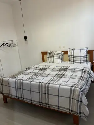 a bedroom with a bed with striped sheets and pillows at Suzanne house in Brussels